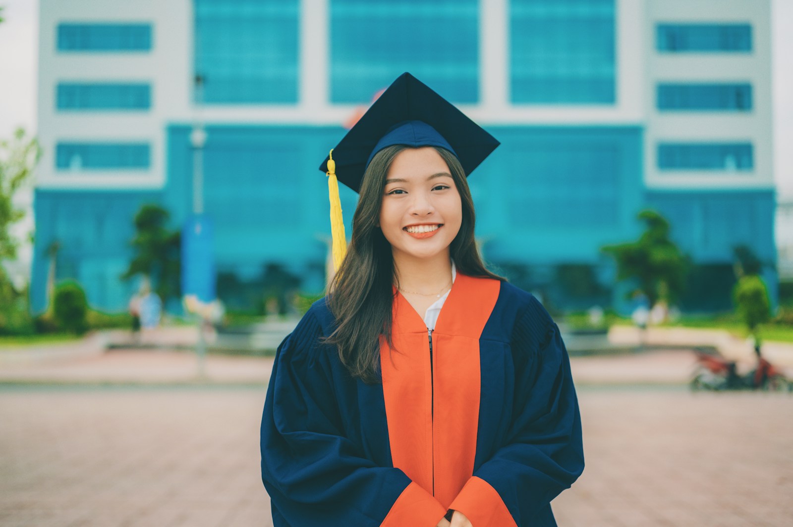 a woman in a graduation gown standing in front of a building